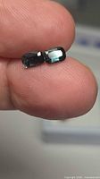 Pair of cushion-cut blue spinels held between fingers