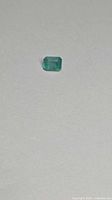 Emerald gemstone on neutral background