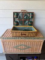 Large wicker trunk with smaller picnic basket open on top showing contents