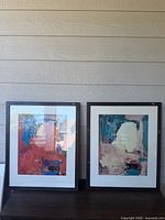 Both framed paintings side by side on surface