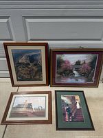 Group shot of all four framed prints standing against garage door