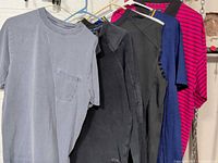 Front view of five tops hanging