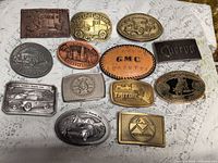 All twelve belt buckles laid out together
