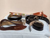 All six belts displayed on cloth