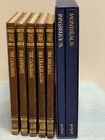 Row of five brown Time-Life books and two blue Olympic books showing spines