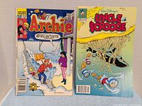 Front covers of Archie #381 and Uncle Scrooge #256 comics