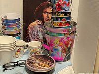 Group view of pails, mugs, tin, glasses, record sleeve