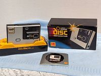 Camera, retail box, and disc film cartridge displayed together