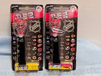 Two unopened NHL PEZ goalie mask dispensers in packaging