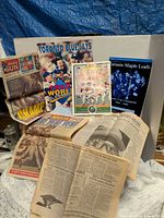 Group shot of all magazines, program, yearbook, and newspaper pages displayed upright and laid flat