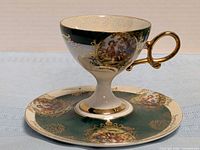 Cup on saucer front view showing pattern and gold trim