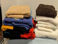 Two stacks of assorted towels showing colours and sizes