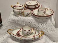 Group view of Limoges dinnerware pieces on lace cloth