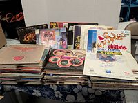 Two horizontal stacks of vinyl albums with visible titles such as Quo Live, Electric Hand, The Clifters