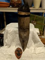 Front view of both wood masks showing size difference and details
