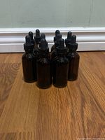 Front view of ten amber glass dropper bottles