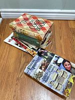 Stack showing Better Homes & Gardens cookbook, Basic cookbook, spiral notebook, magazines, and Enzyme Process catalog