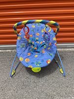 Front view of Bright Starts infant bouncer showing seat fabric, toy bar, frame and feet