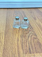 Front view of both faceted glass shakers standing together