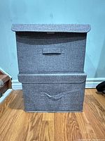 Two gray fabric storage bins stacked with lids