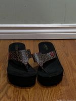 Front view of both sandals showing platform height and monogram straps