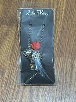 Front view of packaged Julie Wang filigree diffuser necklace
