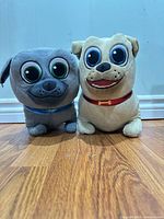 Front view of both Puppy Dog Pals plush toys