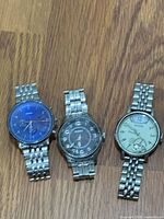 Three Fossil stainless steel watches side by side