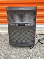 Front view of black LuguLake powered subwoofer speaker showing grille, control panel and attached power cord