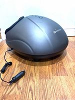 Full view of gray Marnur foot massager with attached car DC adapter