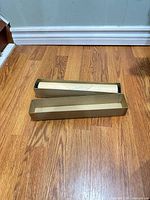 Tube inside outer box on wood floor