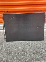 Front view of Samsung subwoofer showing fabric grille and overall wear