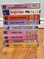 Front spines of all eight Shirley Temple Playhouse Video VHS tapes stacked