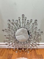 Front view of sunburst mirror showing metal frame and crystal accents