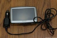 Front view of TomTom GPS with attached car charger cable