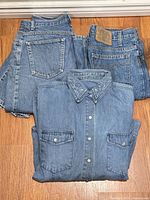 Two folded jeans over folded denim shirt