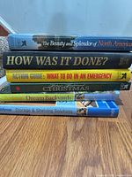 Stack showing books on North America beauty, How Was It Done, emergency guide, Christmas traditions, Dream Backyards, Storage & Shelving Solutions