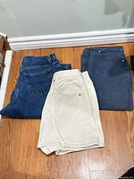 Blue jeans, cream shorts, dark skirt laid out