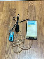 Full view of diffuser showing compressor housing, glass nebulizer on teal base, tubing and power cord