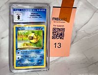 Front view of CGC slab showing grade 8 label and Psyduck card