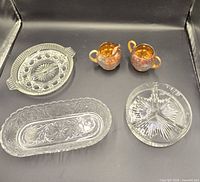 All five items displayed: three glass dishes and two iridescent plastic pieces