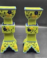 Front view of both lime green floral square tower candleholders