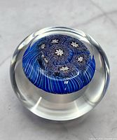 Top perspective showing millefiori floral pattern encased in clear glass