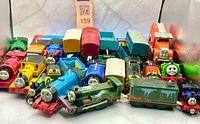 Group shot of approximately 25 Thomas & Friends engines, tenders, wagons and vehicle showing variety and condition