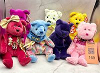 All six bears arranged in two rows showing colours, accessories, and tags