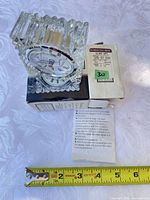 Clock on box with ruler and paperwork showing scale and contents