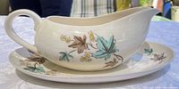 Gravy boat on underplate showing floral decoration and crazing