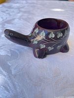 Front angled view of purple wooden animal trinket dish showing bowl opening and painted leaf motif