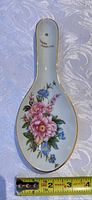 Top view showing floral design, gold trim, inscription, measurement