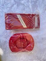 Sealed red rolling slicer body and separate food holder in clear plastic sleeves